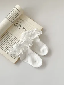 Detailed view of white mesh lace socks with frilly ruffles and polka dot textures