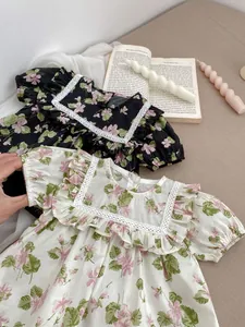 Close-up of floral print baby bodysuits featuring lace square neck and ruffle sleeves