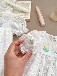 Close-up of girls cotton lace dress showing floral embroidery and elastic puff sleeves