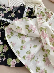 Close-up of floral baby bodysuit with lace trim and cotton linen texture in two colors