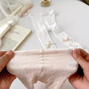 White hollow knit baby tights with bow accents and breathable mesh texture