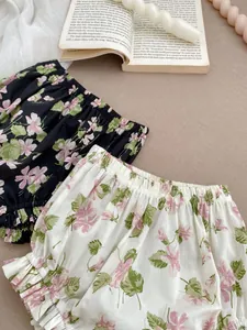 Detail of floral baby bloomers with elastic waist and ruffle hem in two colors