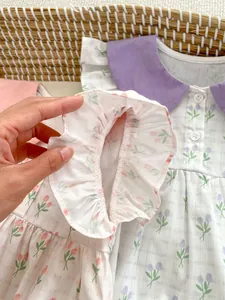 Détail des manches à volants et coutures fines sur le body floral pour bébé