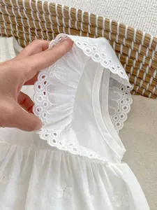 Detail of baby white cotton dress featuring flutter sleeves and eyelet lace embroidery