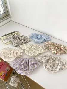 Detailed flat lay of tiered floral baby bloomers with ruffled layers and elastic waist