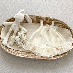 Detail of embroidered floral infant romper dress with mesh ruffles and matching baby shoes