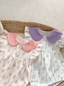 Détail de barboteuses bébé à fleurs avec manches volantées et grands cols ronds