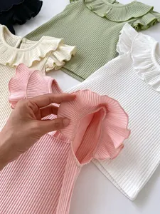 Close-up of flexible ribbed cotton fabric and ruffled flutter sleeves on a baby tee