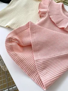 Detailed close-up showing precision stitching and hem finish on ribbed baby tops