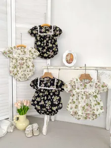 Floral baby bodysuits with lace collars and ruffle details in a vintage room setting