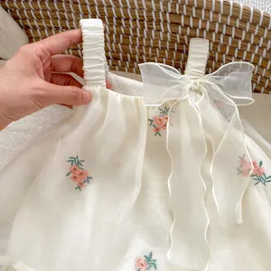 Detail of baby girl floral embroidery on breathable cream tulle with soft gauze bow