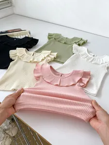 Close-up of elastic ribbed fabric and ruffled neckline details on baby girl t-shirts