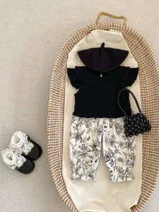 Baby girl ruffle sleeve top and floral bloomers set neatly displayed in a woven basket