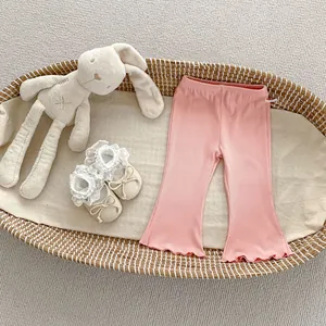 Detail of baby girl pink ribbed flare pants featuring lettuce edge hems and elastic waist