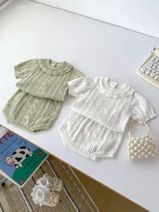 Detail of baby summer knit set featuring hollowed-out patterns and ruffle collar