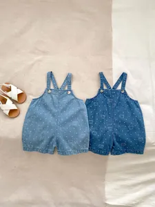 Close-up of baby denim overalls in light and dark blue with cute bear and polka dot prints