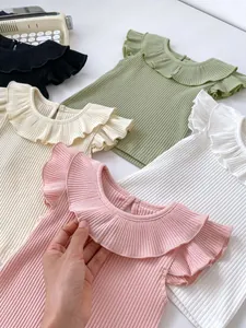 Detail of ribbed knit baby shirts with ruffle collars in various soft pastel colors