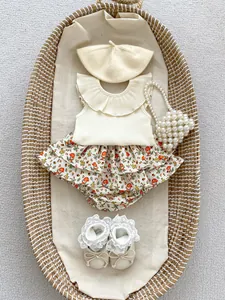 Flat lay of baby girl beige ruffle top and mushroom print tiered bloomers set