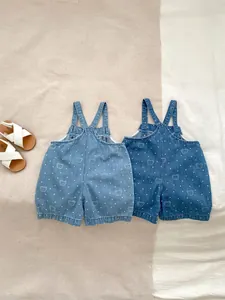 Detailed view of light and dark blue baby denim rompers with cute bear and polka dot prints
