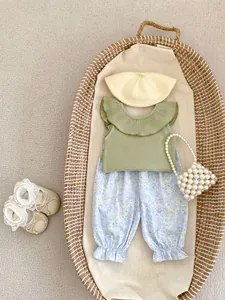 Baby girl summer outfit set with ruffle top, floral pants, and cute pearl handbag accessory