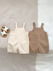 Close-up of cotton linen baby romper shorts set with textured fabric in beige and brown