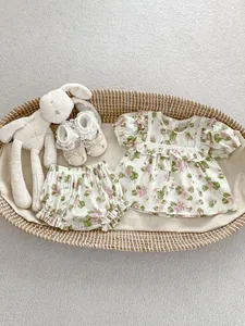 Close-up of floral baby summer set with lace trim top and shorts in a woven basket