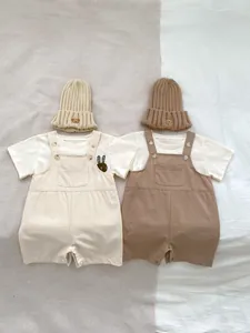 Flat lay of baby summer cotton rompers with bear embroidery hats and rabbit prints