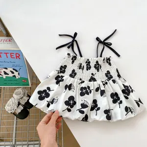 Detailed close-up of girls floral summer top featuring elastic smocking and black bows