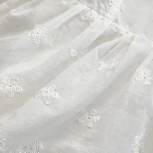 White baby girl romper with floral embroidery and ruffle sleeve details for summer