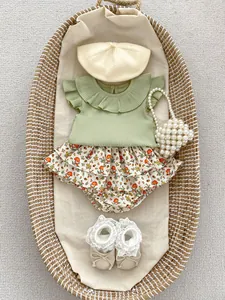 Detail of ruffled sage green baby shirt with floral mushroom pattern bloomer shorts