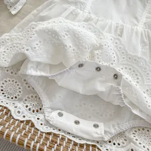 White eyelet lace baby bodysuit with embroidered ruffled sleeves and snap closure