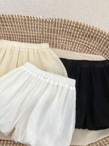 Detail of three summer bloomers in neutral colors with soft pleated texture