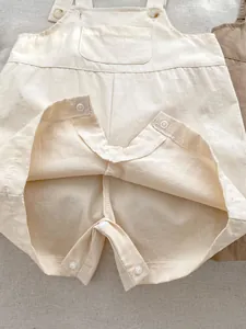 Detail of baby romper with snap button crotch closure and soft cotton fabric texture