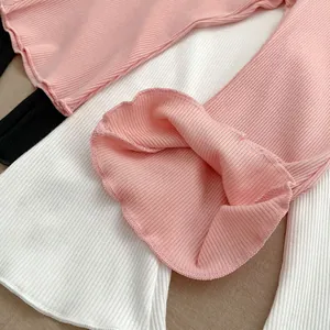 Close-up of girls' ribbed cotton flared trousers featuring tiered ruffled leg opening detail