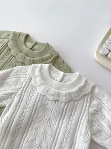 Detail of hollow knit baby sets featuring double-layered ruffle collars and soft texture