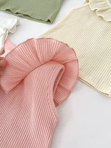 Detailed view of ruffled neckline on ribbed cotton knit vests in pastel summer colors