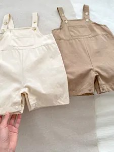 Close-up of baby rompers featuring adjustable straps and snap buttons at the bottom