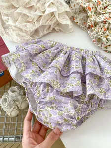 Close-up of baby floral bloomers featuring triple-layered ruffles and soft cotton fabric