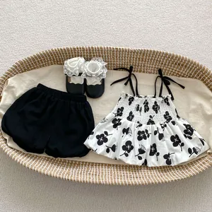 Toddler girl summer floral top and black bloomers set with matching shoes in a cradle