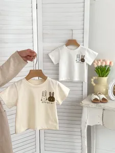 Close-up of baby cotton t-shirts with cute bunny prints and creative hand-drawn text