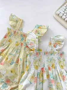 Detailansicht Baby-Body mit Blumenmuster, elastischem Smok und Rüschenschultergurten