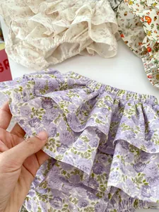 Detail of floral baby bloomers featuring triple ruffled layers and elastic waistband