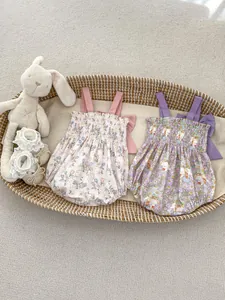 Detailed view of floral baby bodysuits with ruffle trim and cute rabbit prints in a basket