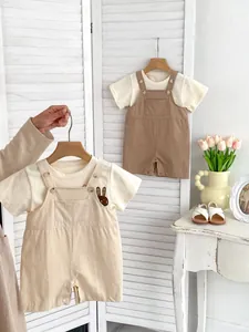 Detail of baby cotton overall rompers with cute rabbit embroidery and front pocket buttons