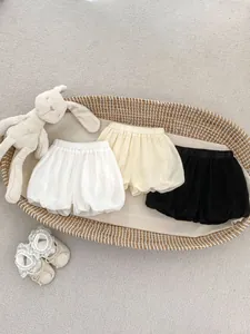 Detailed flat lay of toddler bubble shorts in white, yellow and black colors