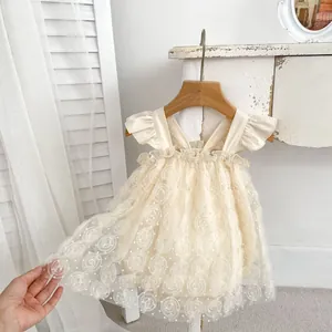 Detail of baby girl tulle romper dress featuring 3D rose embroidery and ruffle sleeves