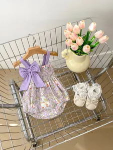 Close-up of floral baby romper with bow straps and matching lace-trimmed shoes