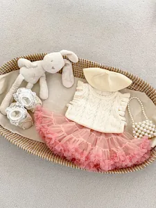 Detalle del conjunto de chaleco de punto y falda tutú rosa para bebé con accesorios