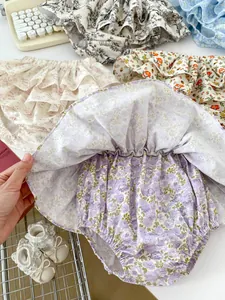 Detailed flat lay of floral baby bloomers with ruffled tiers and elastic waistbands