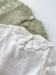 Detail of baby knit set featuring hollow floral patterns and scallop petal collars